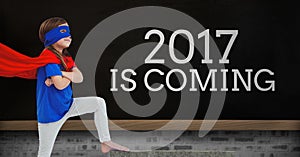 Girl in superhero costume standing near a board with 2017 new year quotes