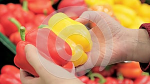 Girl in supermarket chooses paprika. Close up shot