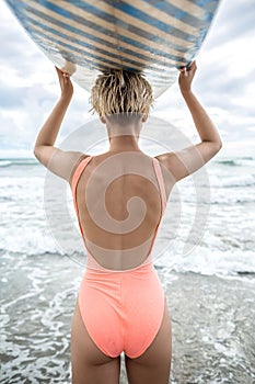 Girl with surfboard on beach