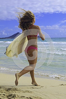 Girl with surfboard running