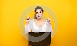 girl surprised look up Point two or more index fingers at the copy area. show some success on a yellow background Concept of