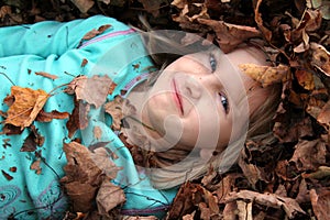 Girl surrounded by leaf pile