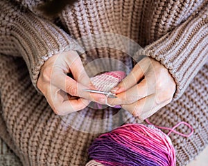 Girl in a sweater knits on needles