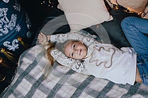 Girl in sweater stretching in bed. Girl having fun in home