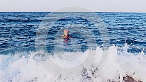 Girl swim in sea wave far from coast. Slow motion