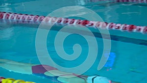 Girl swimmer dive in swimming pool. Female swimmer dives in swimming pool for a swim exercise. Top view.