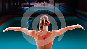 Girl swimmer muscular body in swimsuit at poolside