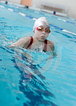 Girl swimming breaststroke in pool