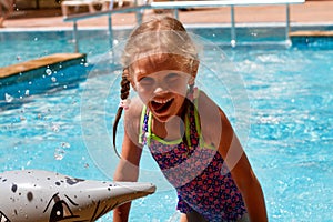 Girl swimming in a pool smiling and having a happy day