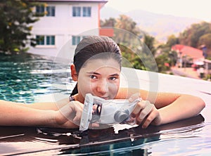 Girl in swimming pool with underwater camera