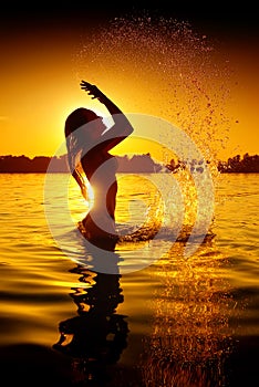 Girl swimming and splashing on summer beach