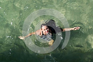 Girl swimming in the stripped dress