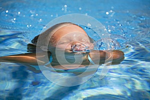 Girl swimming in the swimming pool