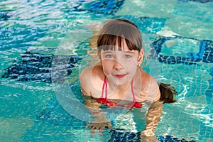 Girl swims in the pool.