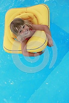 Girl swims in a pool with a circle