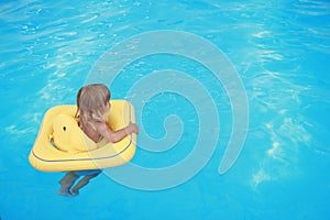 Girl swims in a pool with a circle
