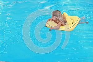 Girl swims in a pool with a circle