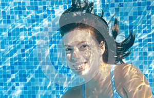 Girl swims in pool underwater, happy active teenager dives and has fun under water, kid fitness and sport