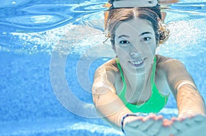 Girl swims in swimming pool underwater, happy active teenager dives and has fun under water, kid fitness on family vacation