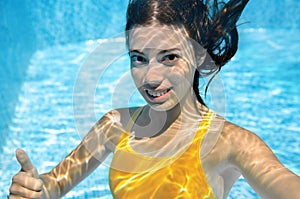 Girl swims in swimming pool underwater, happy active teenager dives and has fun under water, kid fitness on family vacation