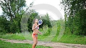 Girl in swimsuit playing tennis outdoors