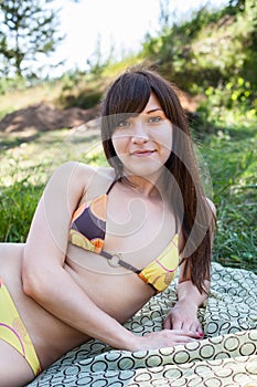 Girl in swimsuit sunbathing on nature