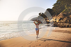 Girl in a swimsuit is walking along the beach on the beach in Thailan