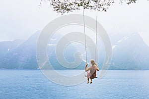 Girl on swing in Norway, happy dreamer, inspiration background