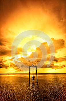 A girl on a swing over the sea at sunset in bali,indonesia 4 photo