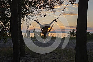 Girl on swing by sea in autumn sunset, family walk in nature, fall vibes, travel, active lifestyle