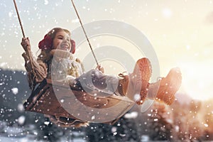 Girl on swing in sunset winter