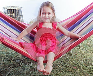 Girl swinging on a hammock in the hay
