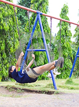 Girl swinging swing in the garden.