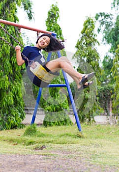 Girl swinging swing in the garden.
