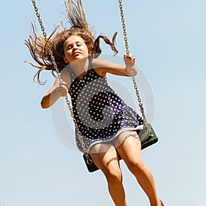 Girl swinging on swing-set.