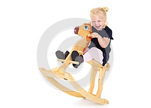 Girl swinging on a wooden horse.