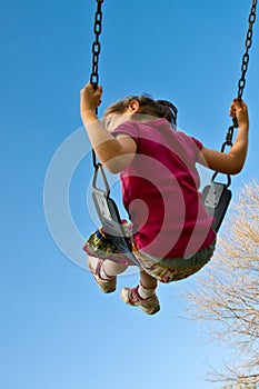 Girl swings into sky photo