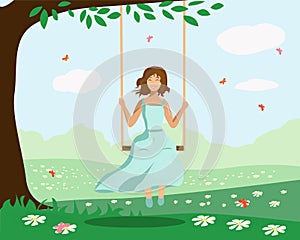 A girl swings on a swing near a tree
