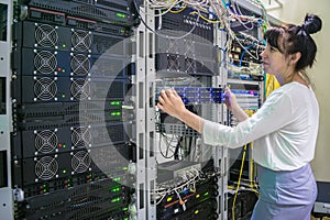 Girl system administrator works with powerful computer equipment. Hosting platform of the Internet provider. A woman installs a