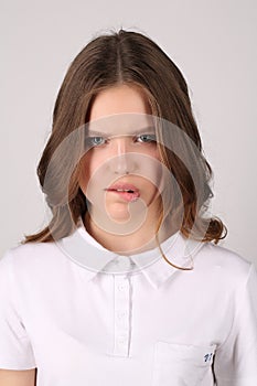 Girl in T-shirt bitting her lip. Close up. White background