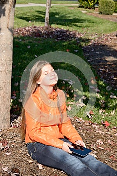 Girl with tablet relaxing in the sun.