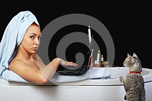 Girl takes a bath and is working with laptop