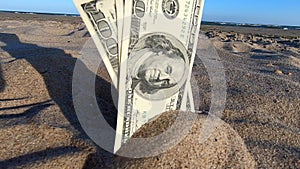 A girl takes out from the sand money notes of three hundred