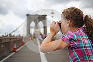 Girl takes pictures on Brooklyn Bridge, side photo