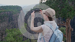 A girl takes pictures on her phone of the landscape of the canyon of Taza. Tazy Canyon in Turkey. Beautiful mountain landscape