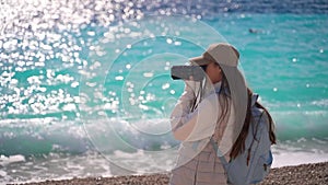 A girl takes pictures of the sea.