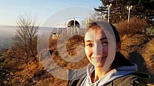 A girl takes a selfie on the background of a gazebo in Kislovodsk Park. Resting woman walks in the huge Park of Kislovodsk.