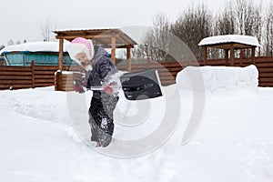 Girl takes snow off the track with a shovel