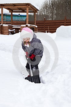 Girl takes snow off the track with a shovel