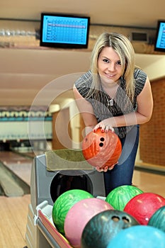 Girl takes two hands ball for playing bowling
